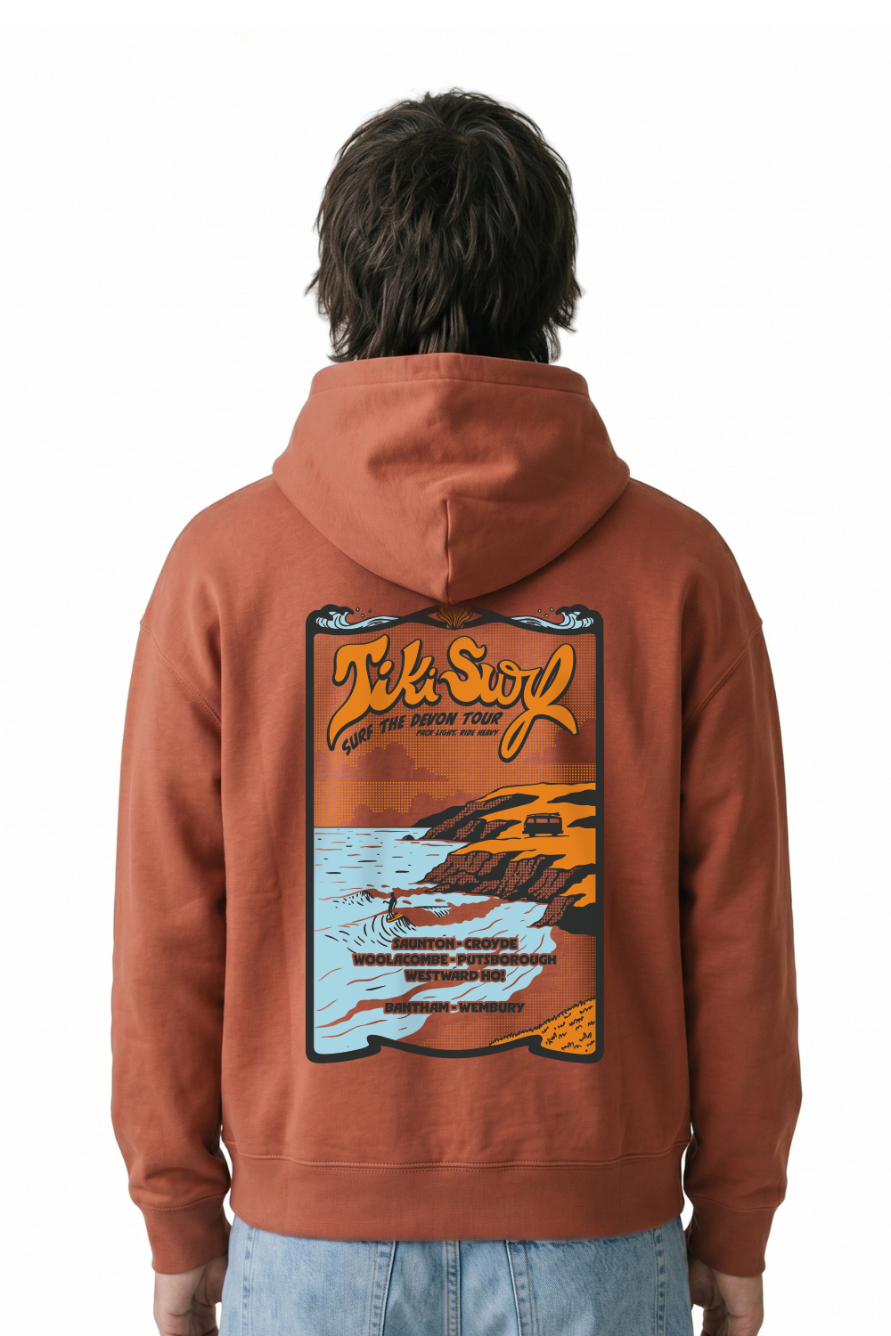 Person wearing a Tiki hoodie in a dark orange Featuring a bold retro back print showcasing Devon’s famous surf beaches.