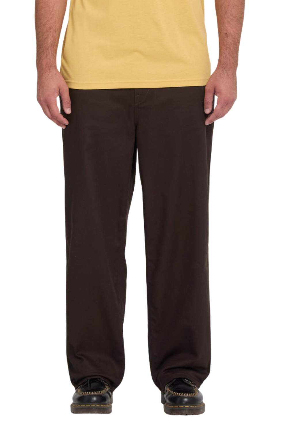 A person wearing dark brown straight-leg Volcom work pants, a yellow t-shirt, and black shoes, shown from the waist down against a white background.