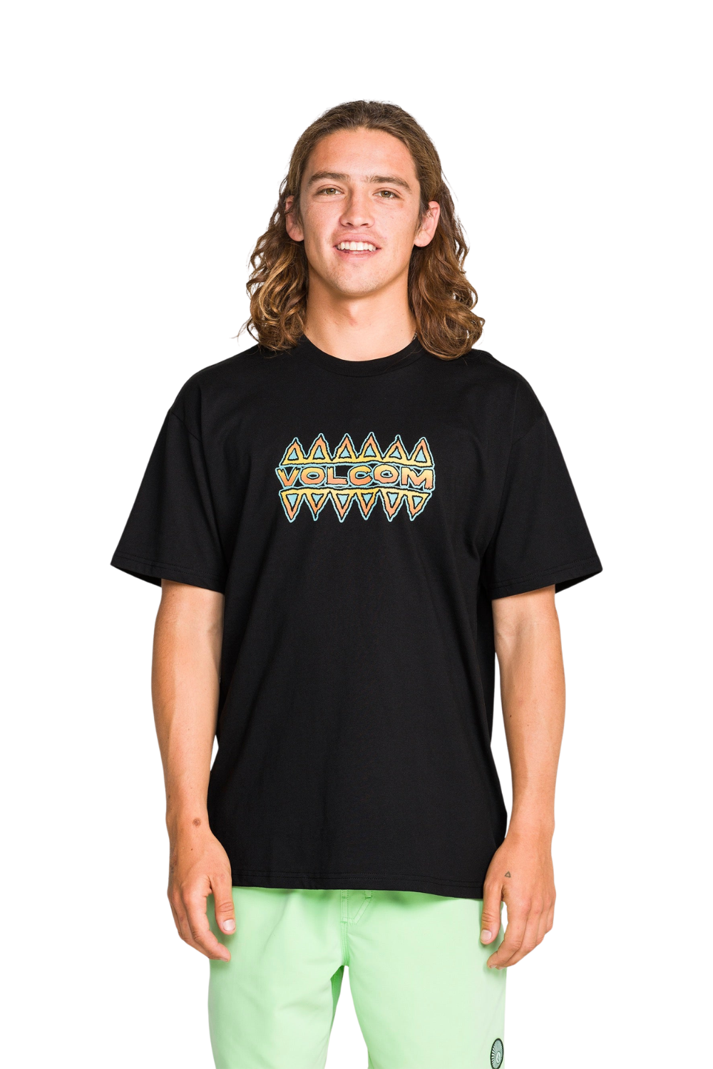 person wearing a black tshirt with a multicoloured graphic on the front that reads 'volcom'