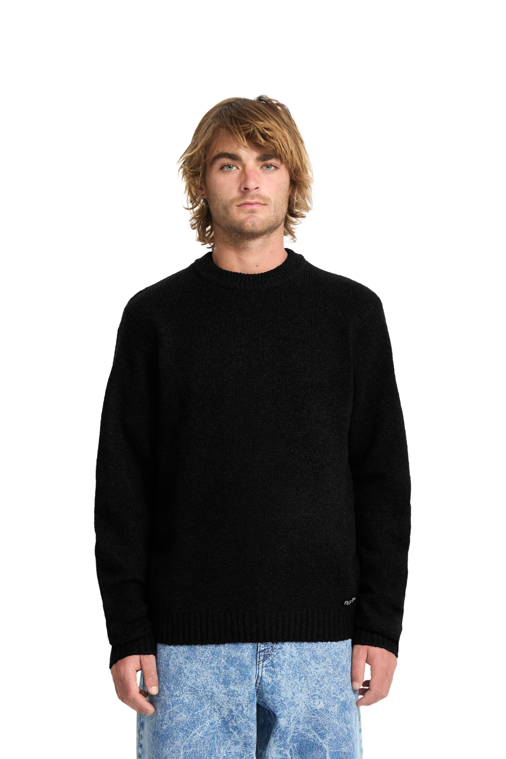 Man wearing a black sweater and blue jeans on a white background