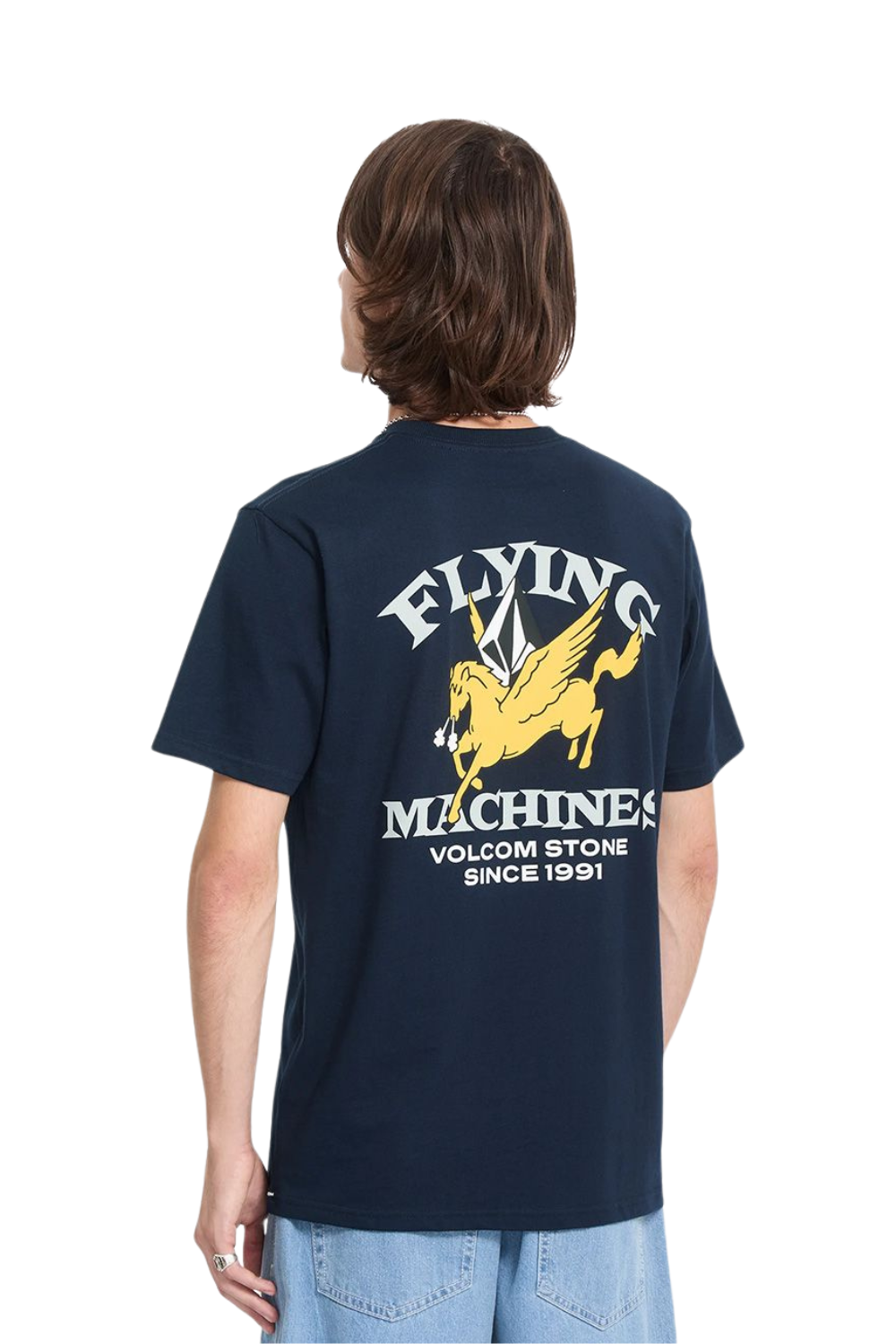 A man viewed from behind wearing a navy t-shirt with a large graphic on the back. The graphic features a beige winged horse (Pegasus) and the text 'FLYING MACHINES VOLCOM STONE 