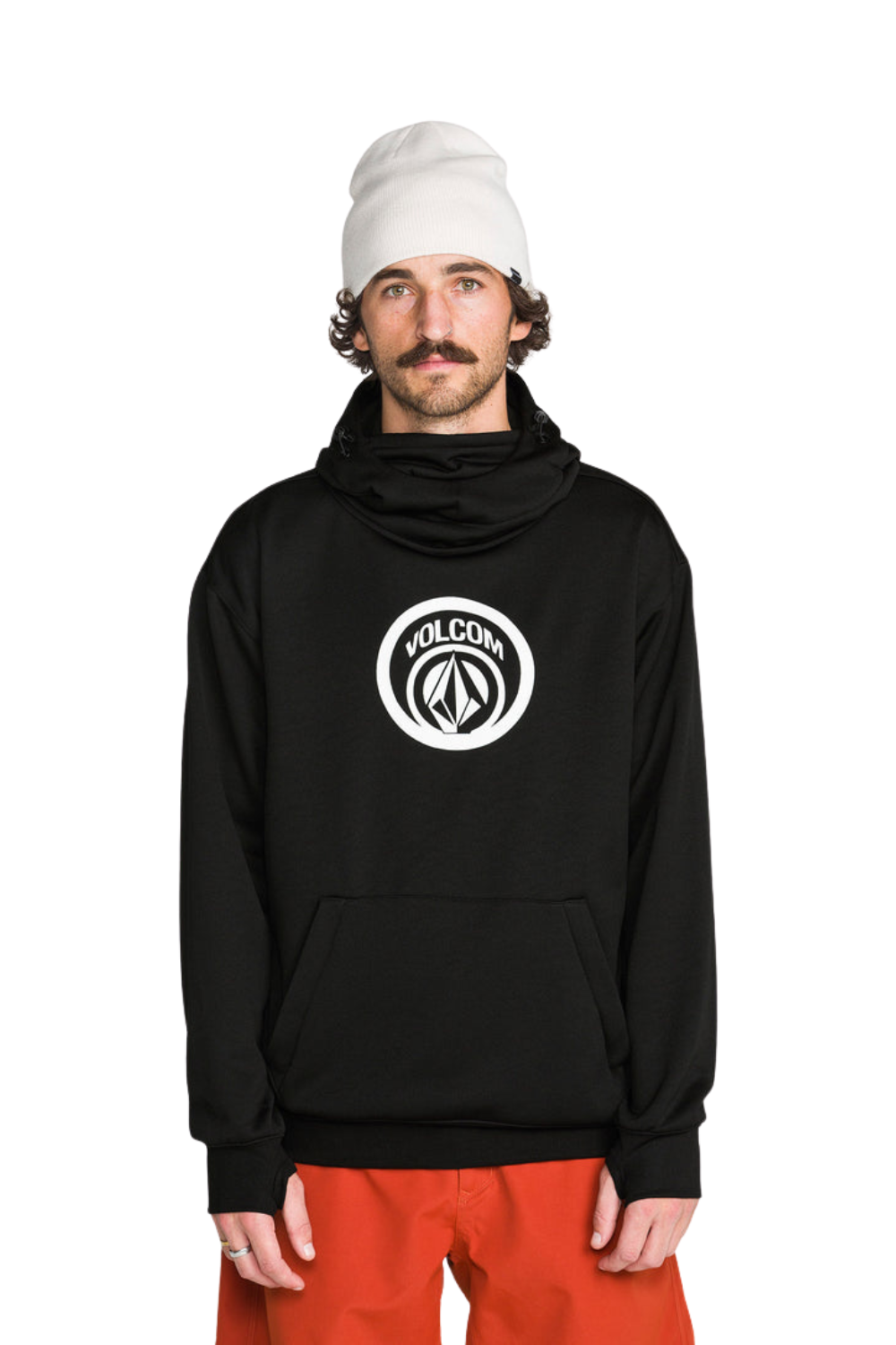 A man wearing a black Volcom pullover hoodie with a white circular logo on the chest, a white beanie, and bright orange pants, photographed against a solid white background.
