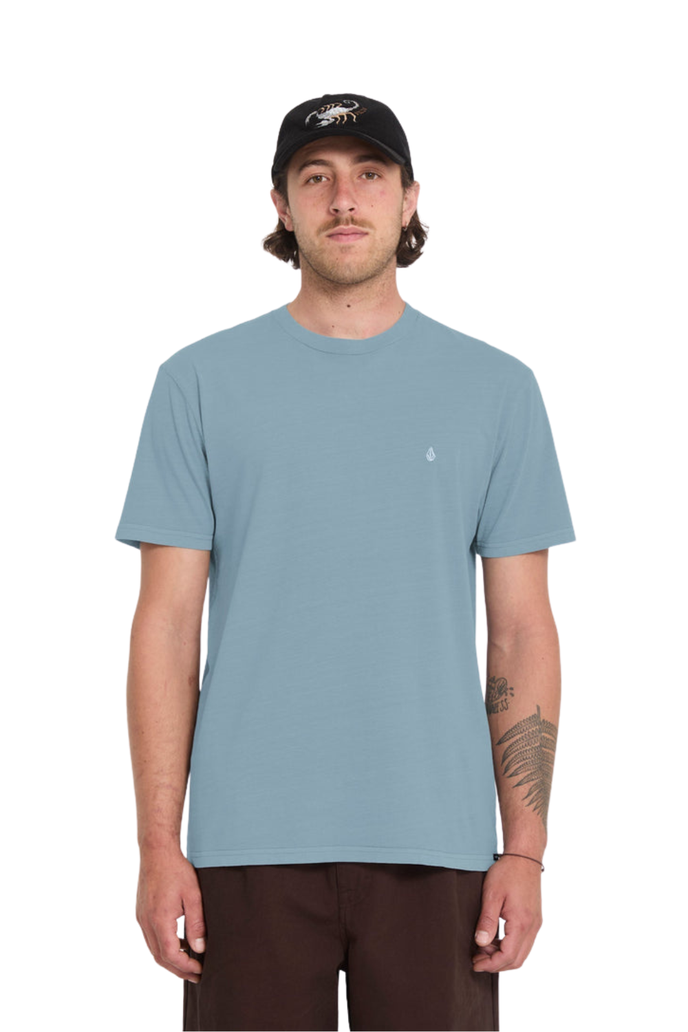 Man wearing a light blue t-shirt and black cap on a white background