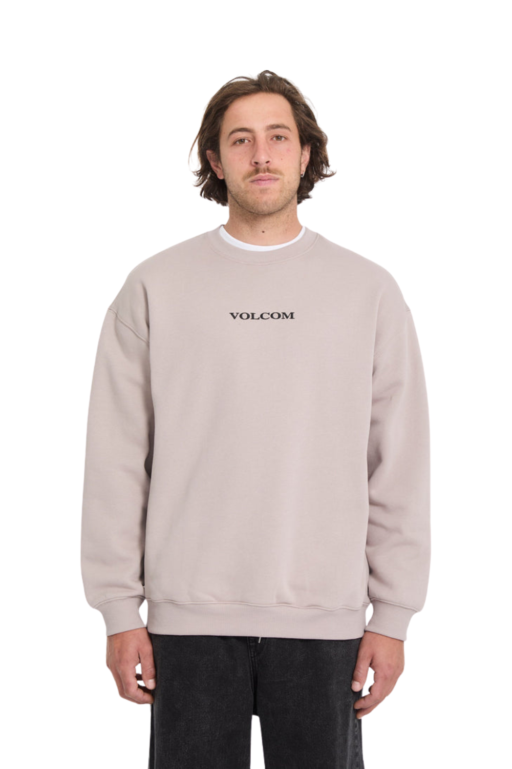 Man wearing a beige Volcom sweatshirt on a white background