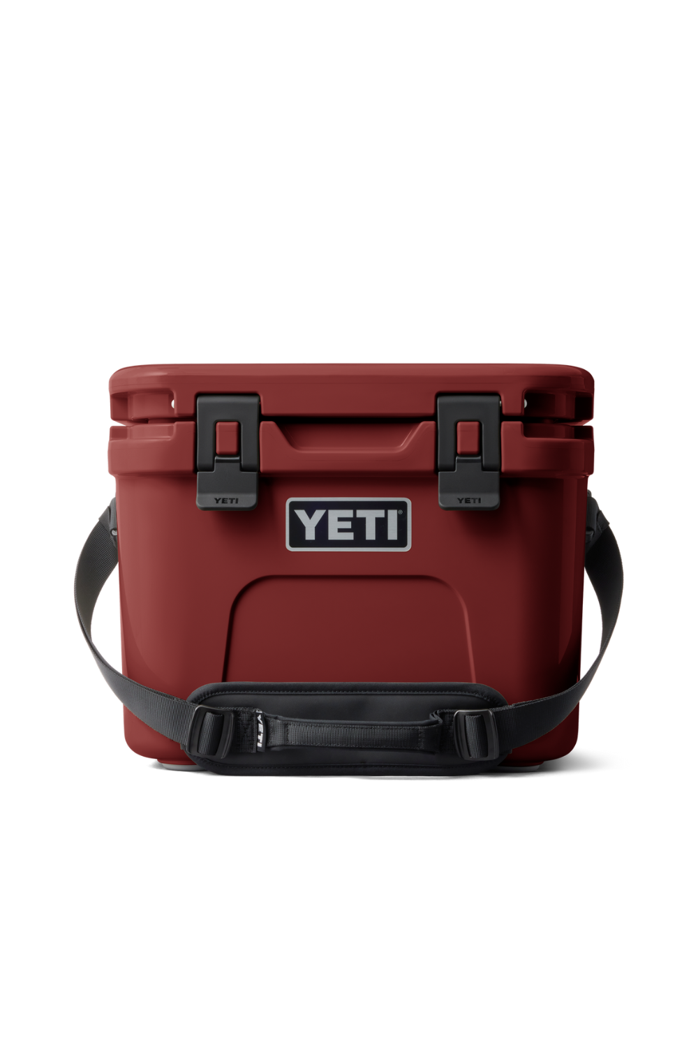 A YETI cooler in matte red with black latches and a black shoulder strap, shown against a plain white background.