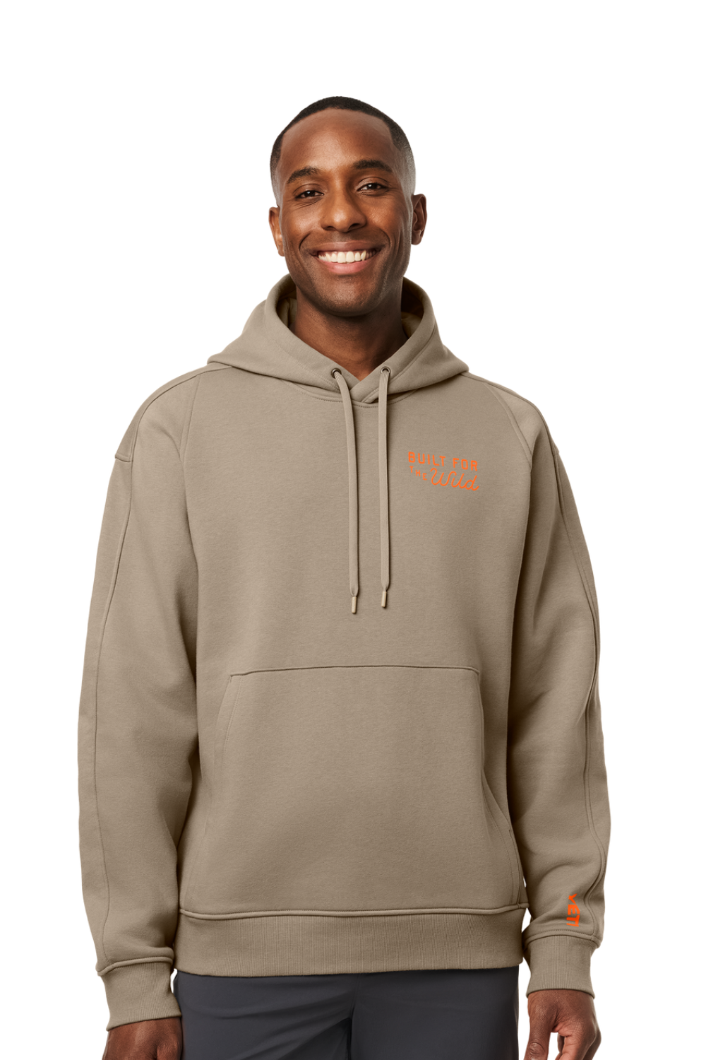 A man wearing a taupe-beige pullover hoodie with a small orange embroidered logo on the left chest and a matching orange logo on the right sleeve cuff, set against a plain white background.